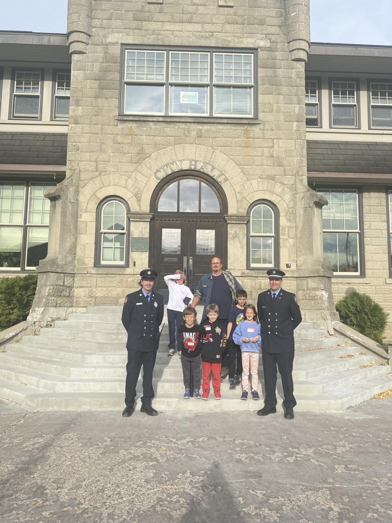 FIrefighters and Deputy Mayor with five students in front of City Hall
